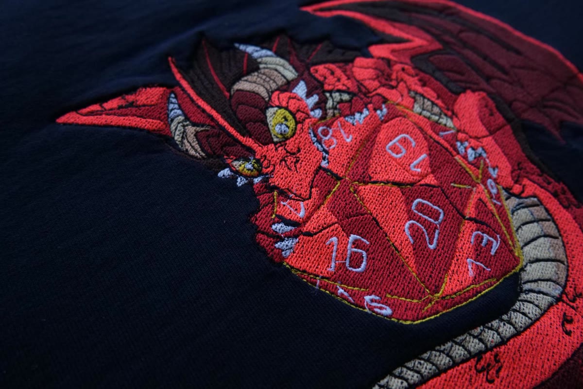 Detail einer roten Drachenstickerei auf dunklem Stoff